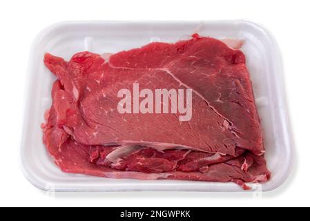 Tranches de bœuf cru, steak de bœuf dans un plateau en plastique alimentaire isolé sur un chemin blanc Banque D'Images