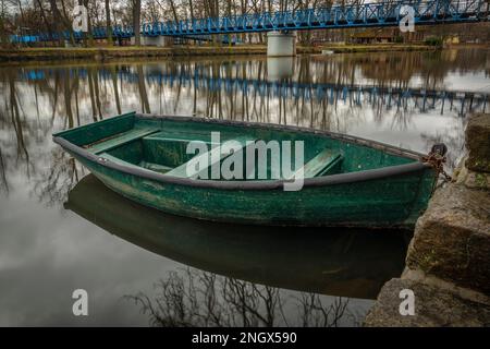 Petit bateau vert en bois sur la rivière Otava dans la ville de Pisek en hiver matin Banque D'Images