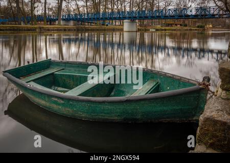 Petit bateau vert en bois sur la rivière Otava dans la ville de Pisek en hiver matin Banque D'Images