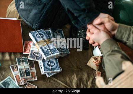 De l'argent sur la table et une poignée de main des hommes à une faible profondeur de champ Banque D'Images