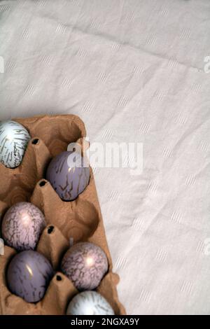 photo d'oeufs de poulet multicolores couchés dans un plateau sur une table Banque D'Images