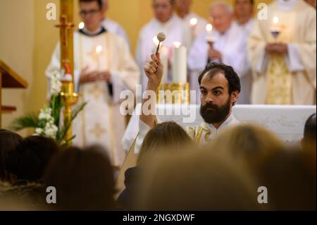 Un prêtre bénit les fidèles avec de l'eau sainte sur la Vigile de Pâques dans l'église Saint-Jacques à Medjugorje. Banque D'Images