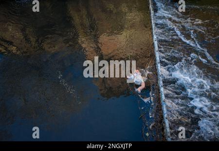 Poupée de bébé de Childs attrapée dans un barrage de captage de métal dans une rivière à écoulement rapide. Banque D'Images