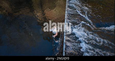 Poupée de bébé de Childs attrapée dans un barrage de captage de métal dans une rivière à écoulement rapide. Banque D'Images