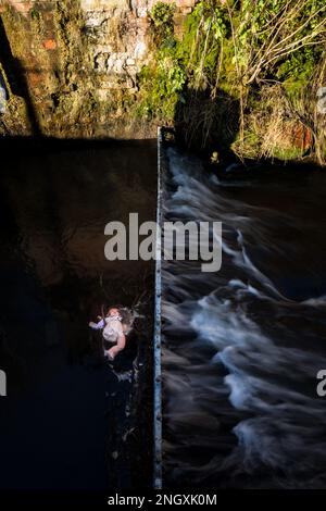 Poupée de bébé de Childs attrapée dans un barrage de captage de métal dans une rivière à écoulement rapide. Banque D'Images