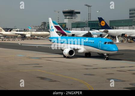 Un KLM Cityhopper Embraer 190 en taxi à l'aéroport de Francfort. L'aéroport de Francfort est l'aéroport le plus occupé par le trafic de passagers en Allemagne ainsi que le 4th aéroport le plus occupé en Europe. L'aéroport est également le 13th plus occupé dans le monde en raison du nombre total de passagers qui manipulent près de 70 millions. Il a également un débit de 2,076 millions de tonnes métriques et est l'aéroport le plus occupé d'Europe par le trafic de marchandises. L'aéroport de Francfort dessert plus de 300 destinations sur 5 continents, ce qui en fait l'aéroport avec les routes les plus directes au monde. Banque D'Images