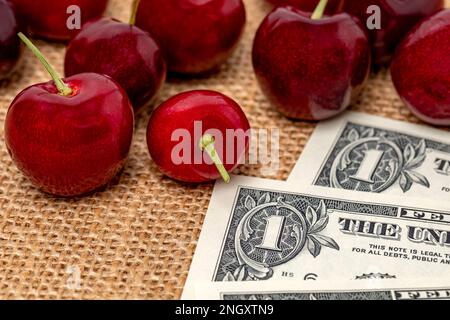Cerises fraîches avec de l'argent liquide. Culture de la cerise, prix et concept de nourriture biologique. Banque D'Images