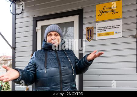 Bucha, Oblast de Kiev, Ukraine. 18th févr. 2023. Une résidente se tient devant son abri temporaire près de sa maison qui a été bombardée il y a un an sur la rue Vokzalna. La femme est restée à Bucha pendant la bataille de mars 2022, elle se cachait dans des abris scolaires locaux. Alors que l'invasion à grande échelle de l'Ukraine par les forces russes approche son premier anniversaire, les résidents de Bucha collectent des fonds pour reconstruire leurs maisons. La plupart des habitants de la rue Vokzalna, l'une des rues les plus détruites lors de la lutte pour défendre Kiev en mars 2022, ont maintenant la chance de reconstruire ou de rénover leurs maisons. Il y a oth Banque D'Images