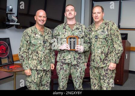 Jim Kilby, Vice-SMA, commandant de la Force opérationnelle 80 et commandant adjoint, États-Unis Commandement de la flotte, à gauche, et le capitaine Steve McDowell, directeur, surface Advanced Warfighting School, à droite, Présenter au lieutenant Kevin Banks une plaque d'honneur pour les diplômés lors de la remise des diplômes du cours d'instructeur sur la tactique de guerre amphibie au détachement Little Creek du Centre de développement de la lutte navale de surface et minière à bord de la base expéditionnaire mixte Little Creek-fort Story, Virginie, le 1 décembre 2022. Les diplômés de 15 de la Marine et du corps des Marines sont chargés de devenir des experts dans le développement de tactiques et de doctrine dans la flotte, ce qui augmente les Tacti Banque D'Images