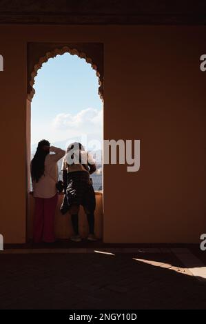 Malaga, Espagne - 14 janvier 2023: Couple de personnes appréciant la vue sur la ville de la fenêtre du palais Alcazaba Banque D'Images