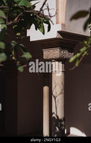 Colonne ornée de décorations en pierre sculptée dans une cour du palais Nasrid, Alcazaba, Espagne Banque D'Images