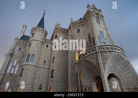 Le Palais épiscopal est illuminé au fur et à mesure que des nuages de tempête se rassemblent à Astorga, Leon, Espagne. Le bâtiment historique de l'architecte catalan Antoni Gaudi se trouve le long de la rue Banque D'Images