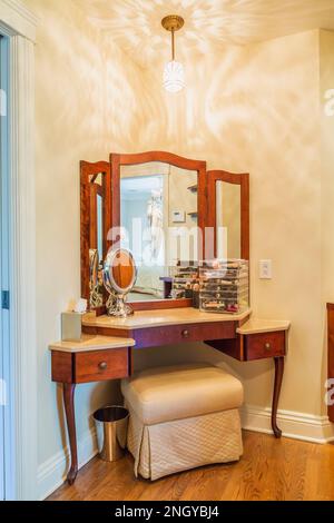 Table de maquillage avec banc rembourré dans la chambre principale en suite à l'intérieur de la luxueuse maison. Banque D'Images