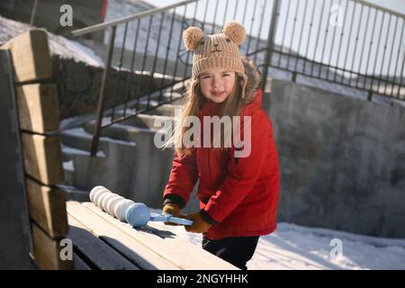 Adorable petite fille jouant avec le snowball Maker à l'extérieur Banque D'Images