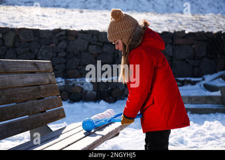 Adorable petite fille jouant avec le snowball Maker à l'extérieur Banque D'Images