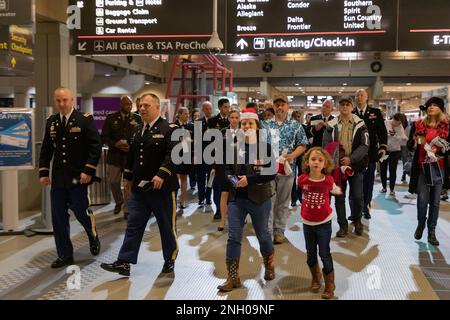ÉTATS-UNIS Les soldats de la Réserve de l'armée, avec le Commandement du maintien (expéditionnaire) 316th, escortent les familles Gold Star pour commencer leur voyage sur le Snowball Express à l'aéroport international de Pittsburgh, Pennsylvanie, le 3 décembre 2022. Le Snowball Express de la Fondation Gary Sinise a été conçu pour offrir une expérience de cinq jours à plus de 1 750 enfants de membres du Service de la chute et à leurs parents ou tuteurs survivants de Walt Disney World, avec un temps spécial pour honorer leurs morts et un mélange de divertissements amusants et de programmes inspirants. Ce sera le premier Snowball Express dans trois ans. Banque D'Images