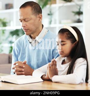 Livres bibliques, famille et enfant dans la prière pour le soutien, la foi et le culte chrétien à la maison. Le père, la petite fille et la prière de la religion, la confiance spirituelle ou Banque D'Images