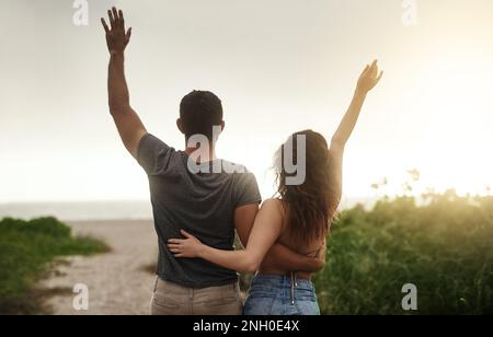L'amour rend la vie complète. Photo d'un jeune couple passant une journée romantique à la plage. Banque D'Images