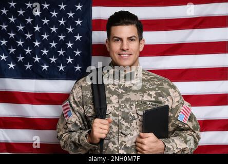 Cadet avec sac à dos et tablette contre le drapeau américain. Éducation militaire Banque D'Images