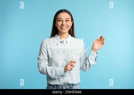 Professeur de musique avec bâton sur fond turquoise Banque D'Images