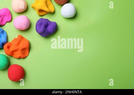 Plasticine colorée sur fond vert, couché à plat. Espace pour le texte Banque D'Images