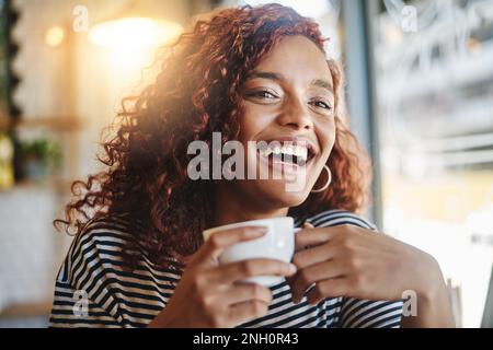 Tout le monde croit en quelque chose. Je crois que j'ai un autre café. une jeune femme attrayante appréciant une tasse de café dans un café. Banque D'Images