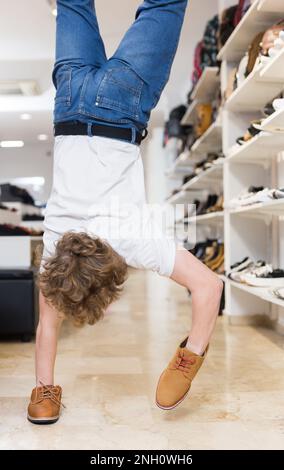 Adolescent faisant la main dans de nouvelles chaussures en daim dans le magasin de chaussures Banque D'Images