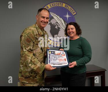 Le colonel Matt Husemann, à gauche, commandant de l'escadre du transport aérien 436th, présente à Rita Sheaffer, adjointe administrative de l'escadron contractant 436th, à droite, un certificat lui reconnaissant comme la première personne de la semaine 436th de l'AW sur la base de la Force aérienne de Douvres, au Delaware, le 5 décembre 2022. Sheaffer a été nommée pour ce prix pour son rendement exceptionnel par ses collègues au CONS 436th. Banque D'Images