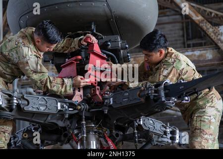 Le SPC. Jose Gonzalez et le Cpl. Luis Sandoval, soldats affectés à la troupe Delta, 3rd escadron, 17th Cavalry Regiment, 3rd combat Aviation Brigade, 3rd Infantry Division, préparent un Apache AH-64 pour un entraînement de pliage de lame sur l'aérodrome de l'Armée Hunter, 6 décembre 2022. Les soldats ont mené la formation pour développer leur vitesse et leur compétence afin de maintenir l'état de préparation de l'unité. Banque D'Images