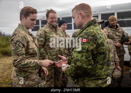 BASE CONJOINTE LEWIS-MCCHORD, WASHINGTON- UN DES ÉTATS-UNIS Le soldat des opérations spéciales de l’Armée de terre du 1st Groupe des forces spéciales (aéroporté) reçoit des ailes aériennes canadiennes d’un soldat de l’infanterie légère canadienne de la princesse Patricia durant la semaine de Menton 2022 à la base interarmées Lewis-McChord, Washington, le 06 décembre. La semaine de Menton est un souvenir annuel d'une semaine de la désactivation de la première Force de service spécial pendant la Seconde Guerre mondiale La FSSF est considérée comme un prédécesseur de la moderne États-Unis Forces spéciales de l'armée. Banque D'Images