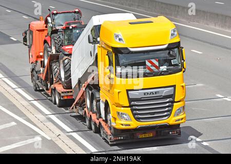 Camion et remorque à chargeur bas avec bases de charge réglables pour les nouveaux véhicules utilitaires tracteurs agricoles camionnette blanche et camion DAF hgv jaune sur la route autoroutière britannique Banque D'Images