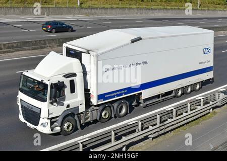 Vue latérale avant aérienne de la chaîne d'approvisionnement des soins de santé du National Health Service DAF CF hgv camion NHS et remorque articulée de conducteur conduisant l'autoroute du Royaume-Uni Banque D'Images