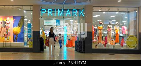 Entrée du magasin de vêtements Primark vue arrière des clients à côté des vitrines du centre commercial intérieur Lakeside centre commercial Thurrock Essex Angleterre Banque D'Images