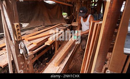 les menuisiers de meubles sont des blocs de bois de lissage à l'aide d'une machine pour faire des besoins intérieurs pour les maisons et les bureaux tels que le remplissage des armoires, des tables, des chaises Banque D'Images