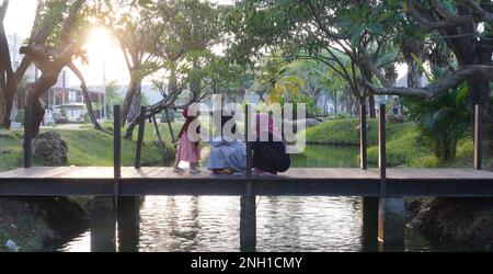 Coucher de soleil cinématographique dans le parc public lorsque les femmes hijab passent du temps ensemble à prendre des photos de selfie Banque D'Images