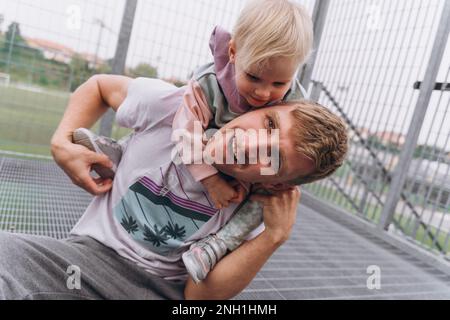 Homme avec petite fille jouant près du terrain de football Banque D'Images