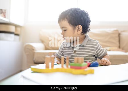 Enfant avec jouets logiques éducatifs dans le salon Banque D'Images