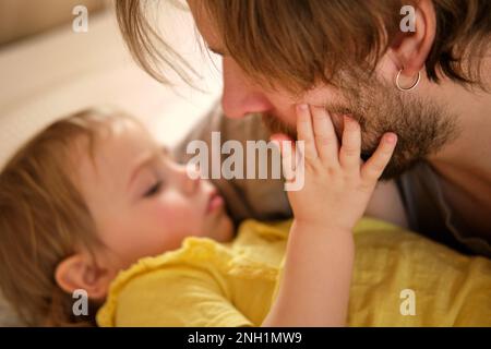 Père heureux avec fille, petite fille. Un an bébé souriant, riant, regardant Daddy. Homme montrant de l'affection à l'enfant. Véritable émotion sincère. Porter Banque D'Images