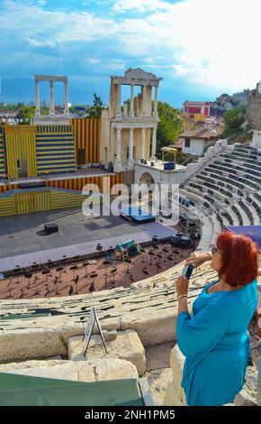 Femme âgée bénéficiant de la vue sur la ville de Plovdiv depuis l'ancien amphithéâtre de style romain restauré et accueillant aujourd'hui divers événements d'arts de la scène. Banque D'Images