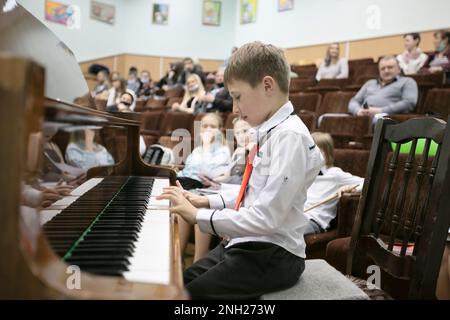 21 mai 2021. Biélorussie, Gomil, Central Music School.l'enfant joue le piano, parle au public. Banque D'Images