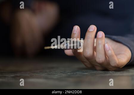 Jeune femme main tenant une seringue et de surdose de drogue, le concept de la criminalité et de la toxicomanie. 26 juin, Journée internationale contre l'abus des drogues. Banque D'Images