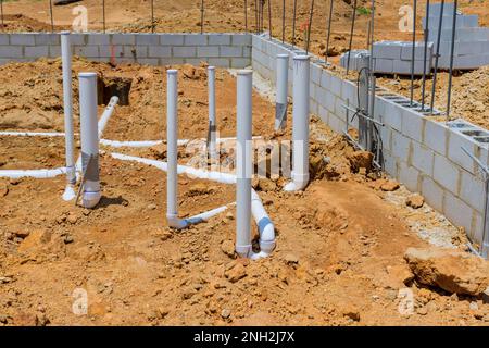 Une nouvelle maison est en construction dans laquelle des canalisations souterraines d'égout et des canalisations d'eau seront enterrées sous la fondation Banque D'Images