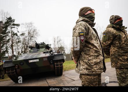 20 février 2023, Basse-Saxe, Munster : les soldats ukrainiens Vitalii (r) et Anatolii se tiennent devant un véhicule de combat d'infanterie Marder lors d'une visite du ministre allemand de la Défense Pistorius à l'école de troupe de chars de Munster, Basse-Saxe. Au cours de sa visite à Munster, Pistorius apprend l'entraînement des soldats ukrainiens sur les principaux chars de combat allemands et les véhicules de combat d'infanterie et discute avec des soldats ukrainiens et des instructeurs allemands. Photo: Christian Charisius/dpa Banque D'Images