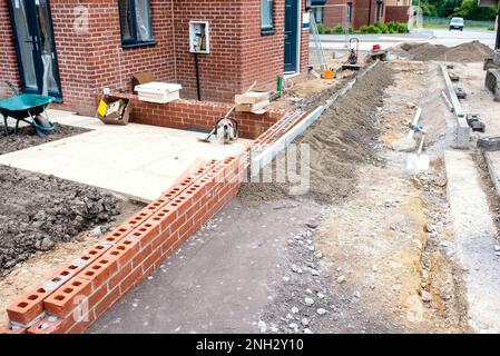 Placer le béton par pelle hydraulique pour les travaux de bordure Banque D'Images