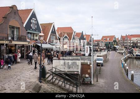 En hiver, les touristes se promènent le long de la promenade du front de mer, près du port, dans la ville de Volendam, aux pays-Bas. Banque D'Images