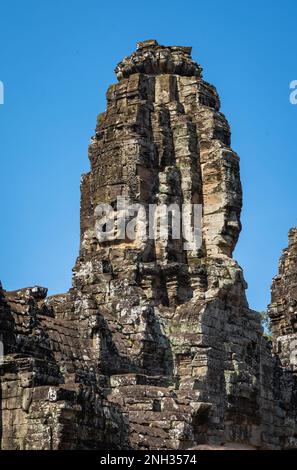 Visages sculptés géants sculptés dans la pierre de l'ancien temple Bayon dans Angkor Thom à Angkor au Cambodge. Banque D'Images