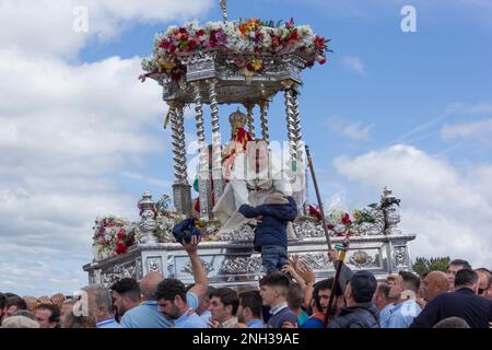 Andujar, province de Jaen, Espagne. Romeria annuelle de la Virgen de la Cabeza. Trône avec la statue de la Virgen et deux prêtres transportés parmi le multit Banque D'Images