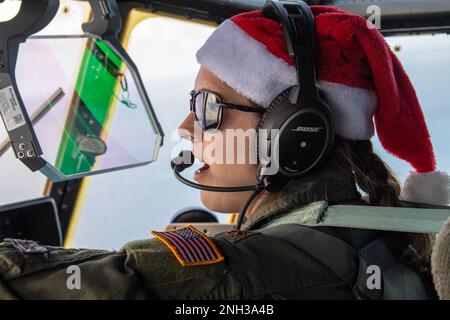 Le Maj Chelsie Jones, 36th Escadron de transport aérien expéditionnaire C-130J pilote Super Hercules, communique avec l'équipage au-dessus de l'océan Pacifique, le 9 décembre 2022, pendant l'opération Christmas Drop 2022. L'avion, le callsign SANTA 67, a été le dernier vol de la mission de l'OCD 2022 et a transporté 9 paquets totalisant plus de 3 300 livres de cargaison à l'atoll de Fananu et de Nomwin dans l'État de Chuuk, États fédérés de Micronésie. Banque D'Images