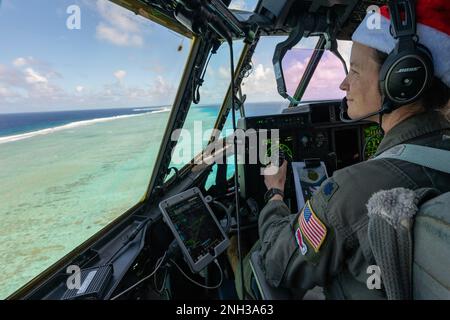 Le lieutenant-colonel Kira Coffey, commandant de l'escadron de transport aérien expéditionnaire du 36th septembre, survole l'atoll de Nomwin dans l'État de Chuuk, États fédérés de Micronésie, le 9 décembre 2022, lors de l'opération Christmas Drop 2022. L'avion, le callsign SANTA 67, a été le dernier vol de la mission OCD 2022. Banque D'Images