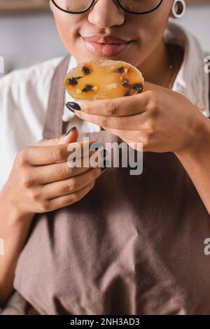 vue rognée de l'artisan afro-américain appréciant la saveur du savon maison dans l'atelier, image de stock Banque D'Images